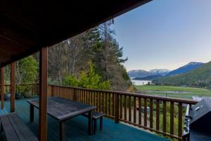 皇后镇Kereru Cottage, Romantic & Beautiful Log Cabin - Queenstown的山景甲板,配有桌子