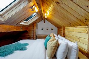 皇后镇Kereru Cottage, Romantic & Beautiful Log Cabin - Queenstown的小木屋内的卧室配有一张床和天窗
