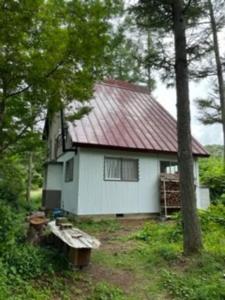 Madarao Kogen大自然の一軒家。便利社会からの逃避、究極のセルフ山小屋ライフ的树林中带红色屋顶的白色房子