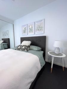 布里斯班Unit 2 - Manly Boutique Apartments的卧室配有一张白色的大床和一张桌子