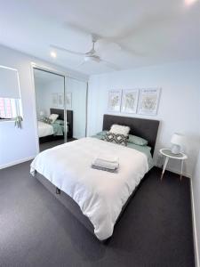 布里斯班Unit 2 - Manly Boutique Apartments的卧室配有一张白色大床和镜子