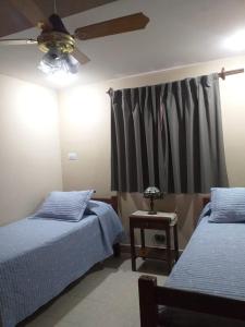 圣米格尔·德·图库玛Tucuman Centro Departamento的一间卧室配有两张床和吊扇