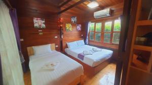 Ban Chong PhliAreeya phubeach resort wooden house的小房间设有两张床和窗户
