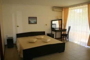 阳光海滩克里苏拉酒店的一间卧室配有一张床、一张桌子和一张桌子