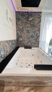 奇维塔韦基亚Suites Matteotti 57的浴缸位于带墙壁的房间