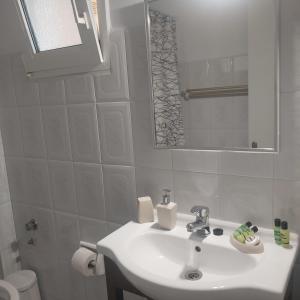 拉瑟Studios Rania - Rania Studios & Apartments的白色的浴室设有水槽和镜子