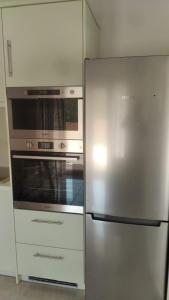 波塔莫斯AVRA-2 Apartments Potamos CORFU的厨房配有不锈钢冰箱和烤箱