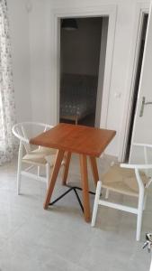 波塔莫斯AVRA-2 Apartments Potamos CORFU的木桌和椅子