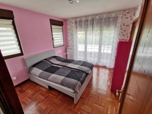 Los TomillaresVILLA TOMILLARES的一间卧室配有一张床和粉红色的墙壁