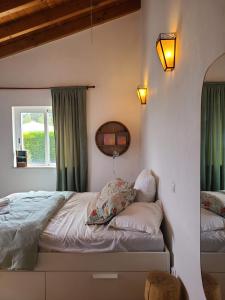 阿尔热祖尔Casa Ensolarada B&B and Pottery的一间卧室配有一张带绿色窗帘的床