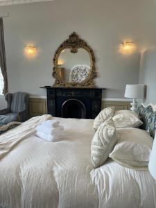 彭赞斯The Old Club的卧室配有白色床和墙上的镜子