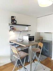 塞尼奥斯Studio ultra cosy et chic avec vue sur l'océan 3*的厨房配有书桌和2把椅子
