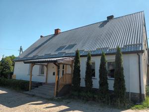 科沙林Studio in Kretomino的一座白色的房子,有金属屋顶和一些树木