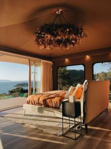 TarakoheDrift Off Grid Luxury Eco Glamping的一间卧室配有一张床,享有海景
