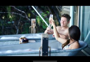 TarakoheDrift Off Grid Luxury Eco Glamping的男人在浴缸里拍女人的照片