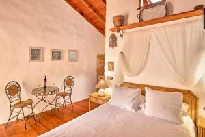 塔科龙特Finca Arce Live Canarias的卧室配有一张床和一张桌子及椅子