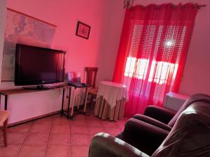 莱佩Habitación con baño Malva的客厅设有粉红色的墙壁和平面电视。
