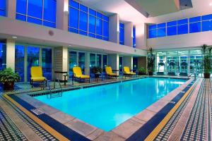 庞蒂亚克庞蒂亚克奥本山万豪酒店的一座大型游泳池,位于一座带黄色椅子的建筑内