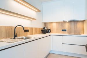 米德尔克尔克Belcasa Mar Suites & Lofts的厨房配有白色橱柜和水槽
