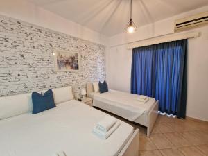 卡萨米尔Villa White的一间卧室设有两张床和砖墙