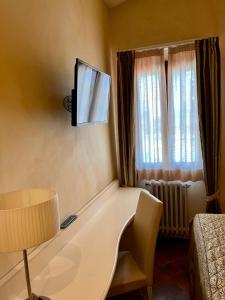 Rodigo蒂格里920自由度假别墅酒店的一间设有桌子和墙上电视的房间