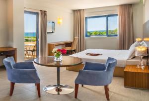 卡纳里奥洛里安西罗克斯尼亚酒店的酒店客房带一张床、一张桌子和椅子