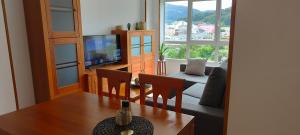 比韦罗Alojamientos Viveiro - Playa de Covas II的客厅配有桌子和电视