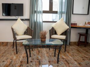 SalalahSAMA Jabal Samhan Hotel的客厅配有两把椅子和一张茶几