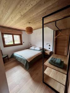 夏蒙尼-勃朗峰Chalet Le petit paradis - Chamonix-Mont-Blanc的一间卧室设有一张床和木制天花板