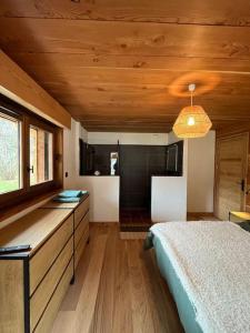 夏蒙尼-勃朗峰Chalet Le petit paradis - Chamonix-Mont-Blanc的一间卧室设有一张床和一个窗口,还有一个厨房