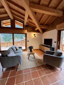 夏蒙尼-勃朗峰Chalet Le petit paradis - Chamonix-Mont-Blanc的客厅配有两张沙发和一台电视机