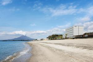 TarumizuFairfield by Marriott Kagoshima Sakurajima的享有海滩美景,设有一座位于后面的建筑
