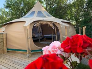 IdestrupRomantic Luxus Glamping 3的一个大帐篷,前面有种鲜花的甲板