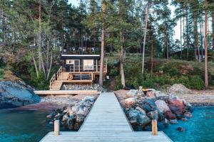 萨洛Saunamäki Resort - Lux Villa的通往水面的木道房子