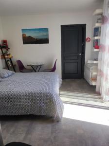 莱萨布勒-多洛讷Chambre et salle d'eau dans dépendance 20 m2, vélos的一间卧室设有一张床和一个黑色的门