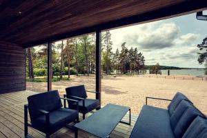 萨洛Saunamäki Resort - Beachfront的一个带椅子和桌子的庭院,享有海滩美景