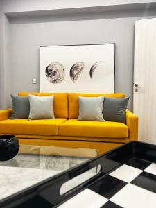 特里波利斯Aire的客厅里一张黄色的沙发,铺有 ⁇ 格地板