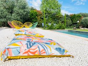 圣萨蒂南艾普特villa Luberon的游泳池旁一张带五颜六色毯子的床