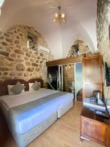 马尔丁达拉康纳吉酒店的一间卧室设有一张床和石墙