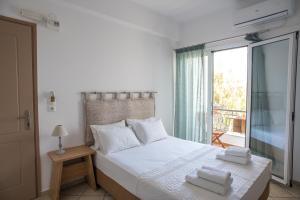 斯基亚索斯镇Annis House的一间卧室配有一张带白色床单的床和一扇窗户。