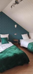 Saint-Benoît-sur-Loirela madeleine的一间卧室配有两张带绿床单的床