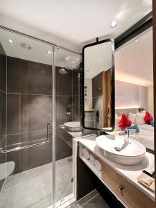班加罗尔Aiden by Best Western Hennur的带淋浴、盥洗盆和镜子的浴室