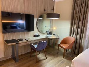 麦地那Roya Al Andalus Hotel的酒店客房配有书桌和镜子
