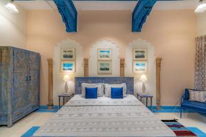 古尔冈Stay Vista at Khohar Haveli - 18th Century Palace with Modern Amenities的一间卧室配有蓝色的床和两张蓝色椅子