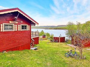 Karpbukt7 person holiday home in JARFJORD的一辆红色的房子,一辆自行车停在草地上