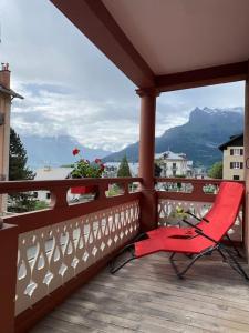 圣热尔韦莱班Appartement Saint-Gervais-Les-Bains的山景阳台上的红色椅子