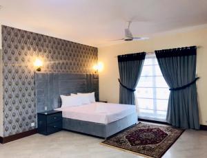 伊斯兰堡Royal Palace Boutique Hotel的一间卧室设有一张床和一个大窗户