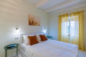 斯维特温斯纳特CASA MARIO-charming stone house with jacuzzi的卧室配有白色的床和窗户。