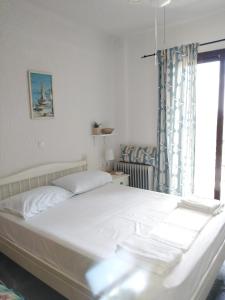 希维利Rebekka's Guest House Elani的卧室配有白色的床和窗户
