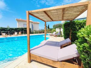拉格尼西Summer Villa Lagonissi的一个带床和凉亭的游泳池,毗邻一座房子